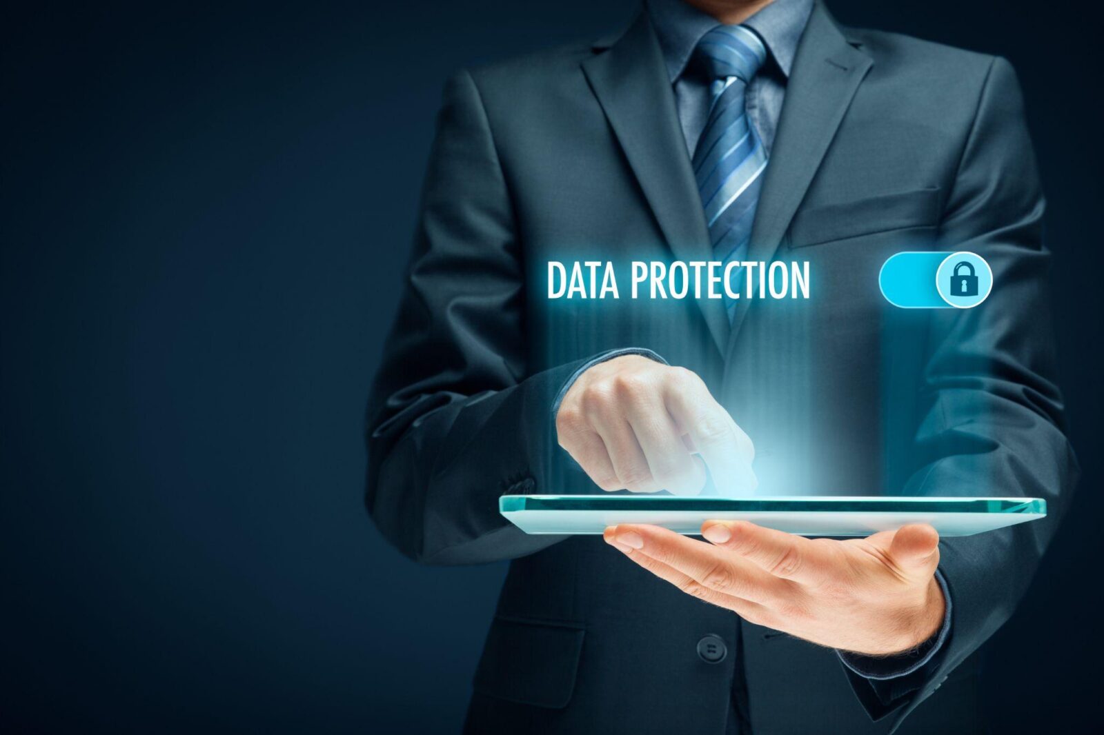 A businessman taps on a digital tablet with the words 'Data Protection' glowing above.