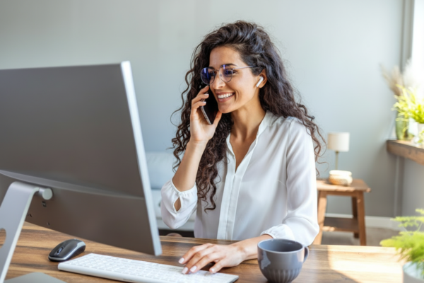 A smiling professional at her desk takes a phone call that was answered right away